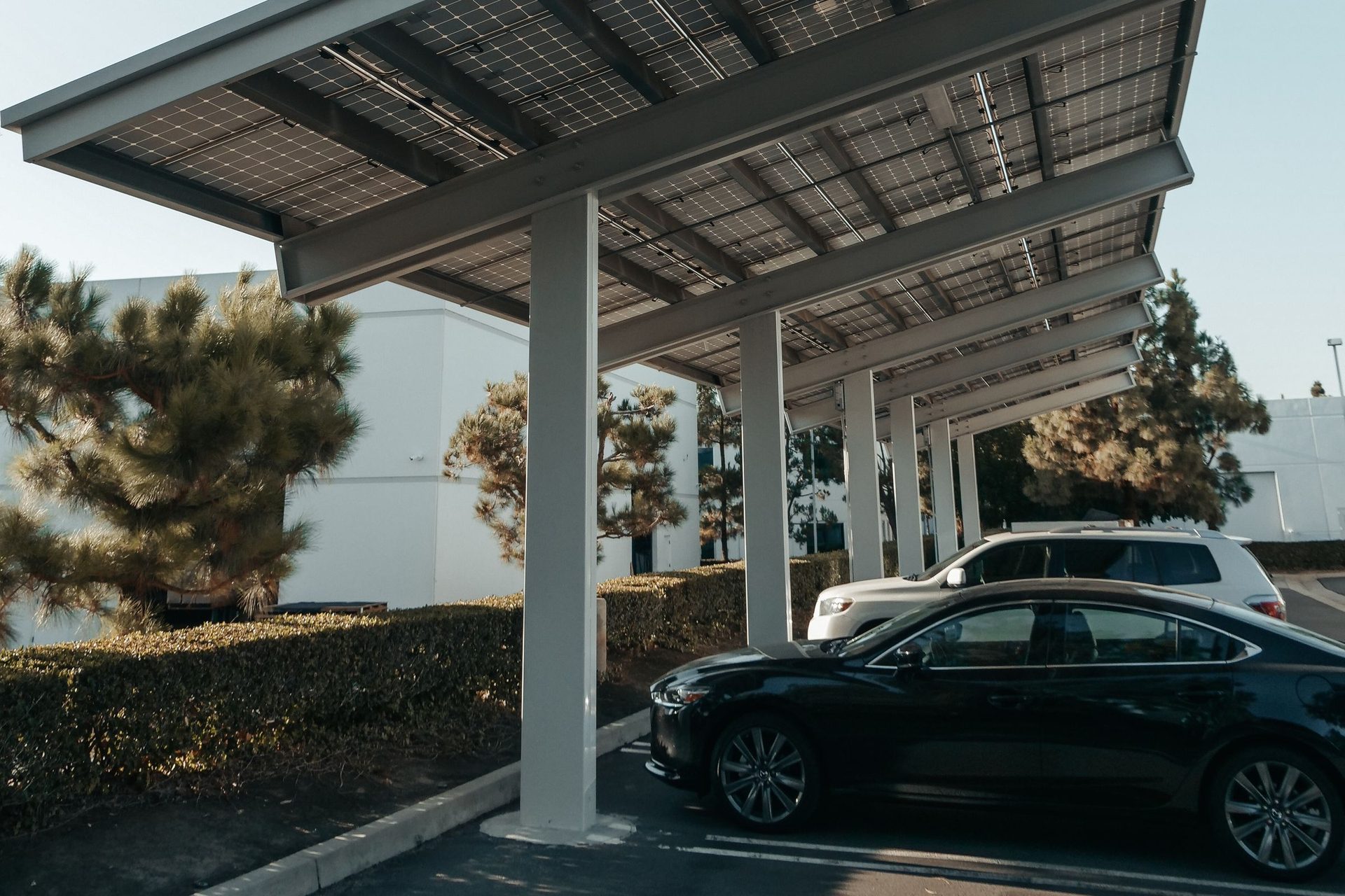 Ombrières photovoltaïques au-dessus d'un parking avec véhicules garés en dessous, en Gironde